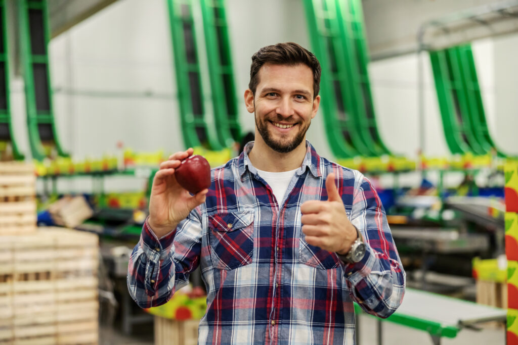 Rural male entrepreneur stands in his production plant and proud